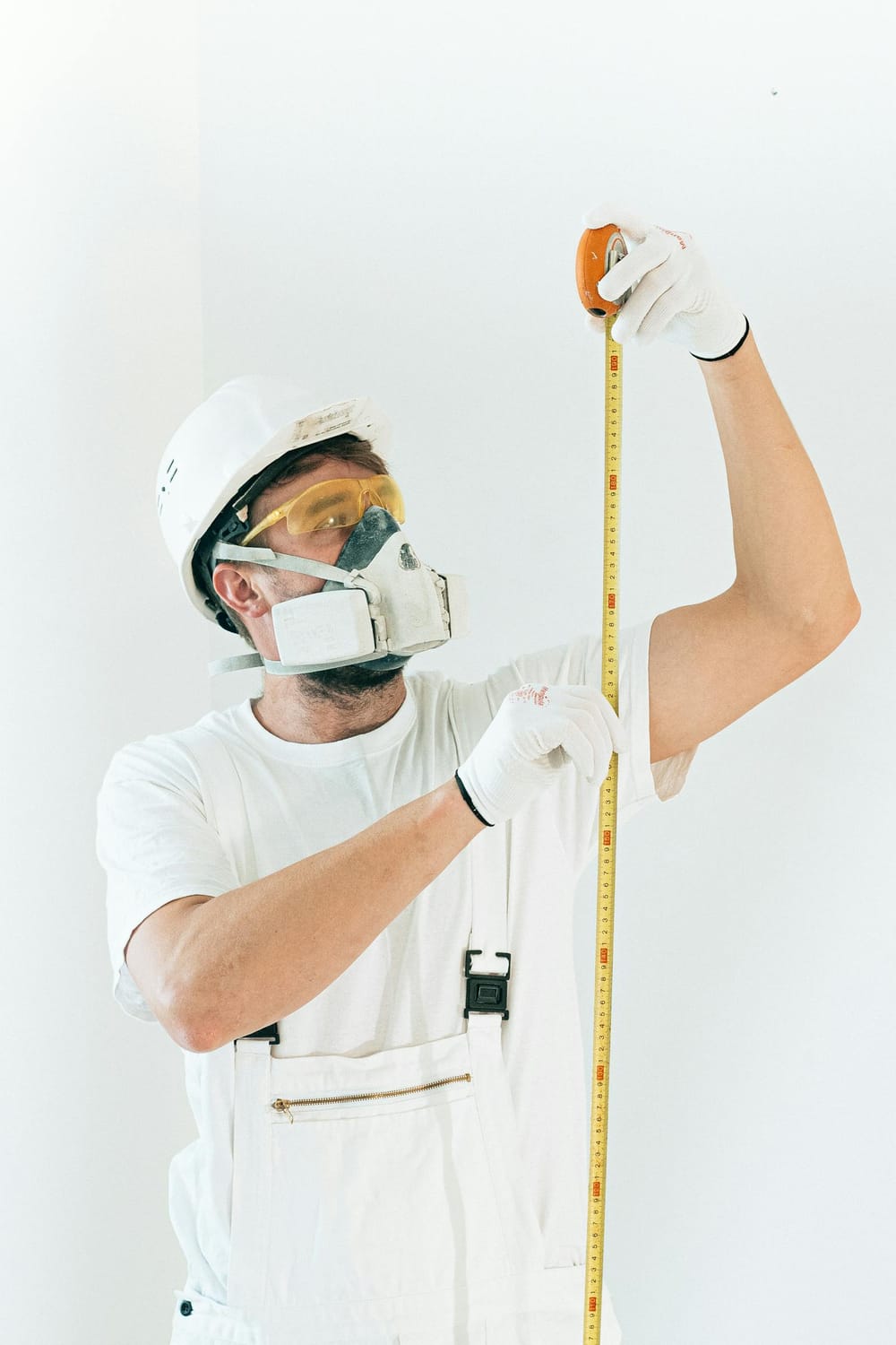 Illustrative example of a contractor measuring a space with a tape measure during a free on-site quote visit